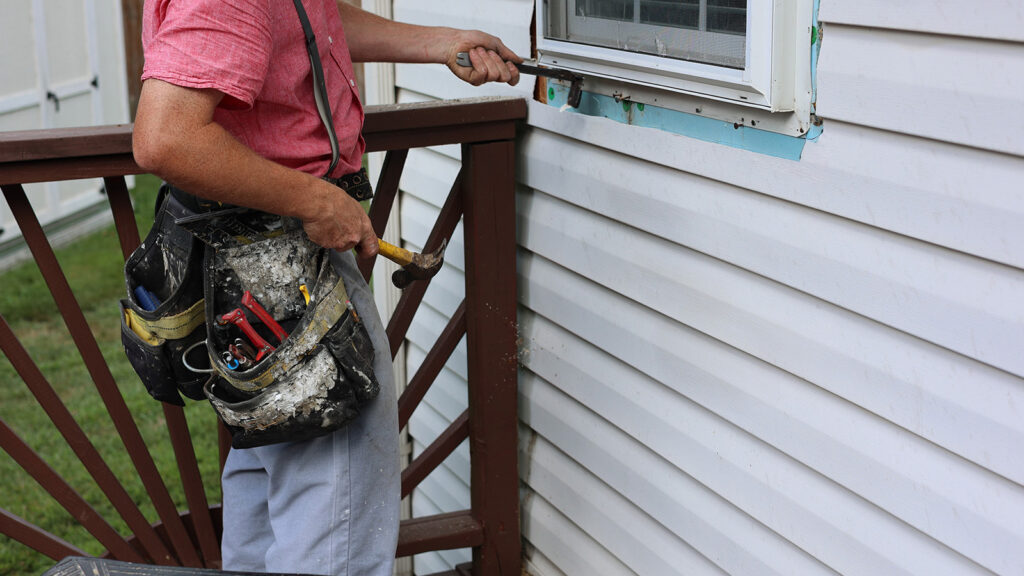 A portrait of a white man installing new windows